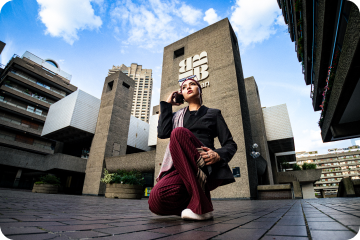 Woman in a headscarf on a phone call in front of the Barbican Centre (next project link)