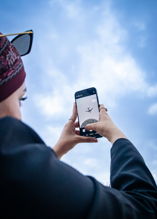 Overhead shot of a woman sitting on a bench scrolling on her phone